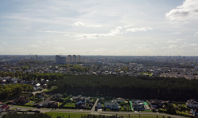 Beautiful top view of the forest and suburb with houses and a park