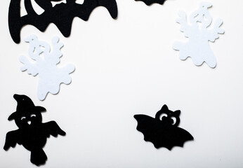 Frame of halloween decoration on pastel white background. Flat lay spooky spiders, bat, insects. Top view with copy space. Holiday greeting card mockup.