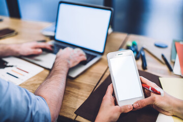 Anonymous office workers using gadgets over table
