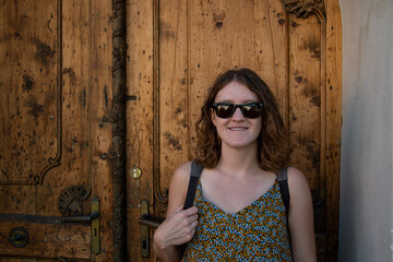 Fototapeta premium Young attractive woman in sunglasses in front of an old wooden door