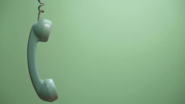 Retro green telephone tube on green background with copy space. Waiting telemarketing phone call.