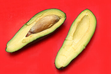 Open avocado on red background