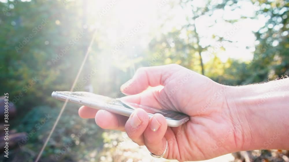 Poster using a mobile phone in hands in the sun, press your fingers on the screen. checking email using mob