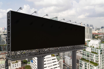 Obraz premium Blank black road billboard with Bangkok cityscape background at day time. Street advertising poster, mock up, 3D rendering. Side view. The concept of marketing communication to promote or sell idea.