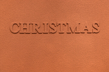 Fototapeta na wymiar Christmas inscription sprinkled with cocoa powder. Cocoa powder texture. Abstract Christmas background.