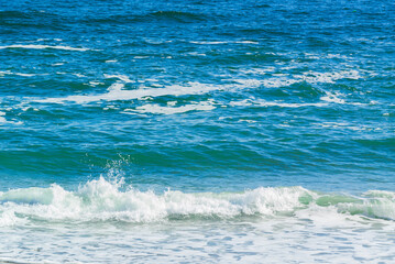 Sea with little waves and foam near the shore