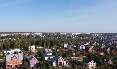 Top view of suburban villas near the park. Landscape with roofs of small houses