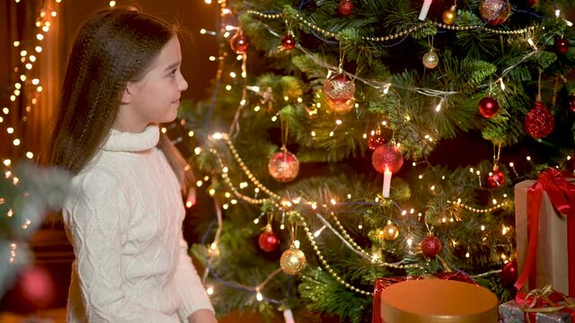 Happy little girl decorating christmas tree with balls. children decorating a Christmas tree.