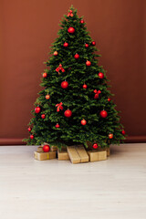 Fototapeta na wymiar Christmas tree pine with red decor with gifts interior postcard for the new year