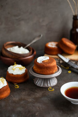 Homemade cupcakes with cream cheese on a small ceramic stand. Food photography on dark backgrounds.