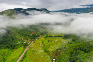 Aerial view over valley surrounded by mountains and covered with dense ground fog and mist High peaks wonderful morning sunrise natural Landscape. Sapan village, nan province, Thailand.
