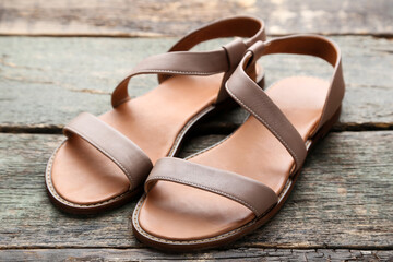 Female beige sandals on grey wooden table