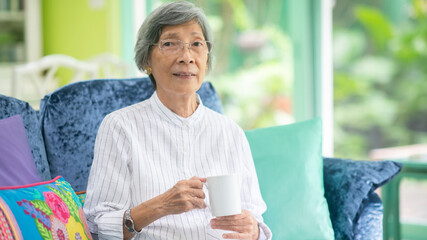 Asian senior woman drink coffee at home. Sustainable lifestyle concept - Powered by Adobe