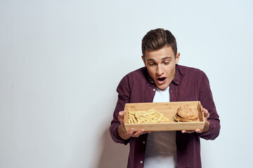 Man eating wooden pallet fast food french fries hamburger diet food restaurant light background