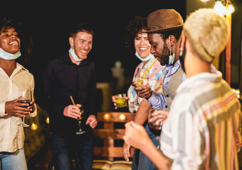 Cheerful multiracial people dance together while wearing surgical face mask under the chin - Home private party