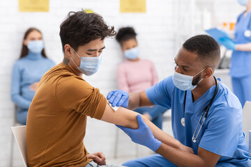 Fototapeta premium Asian Man Receiving Coronavirus Vaccine Injection During Appointment In Hospital