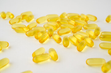 dietary nutrition healthy concept of many yellow softgels fish oil omega3 on white surface with copyspace