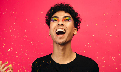 Excited gay man with glitters