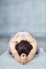 Frau/M&auml;dchen in Pastell gekleidet macht Outdoor Yoga &Uuml;bungen/Sonnegru&szlig;/Child's Pose in moderner Beton Architektur. Urbanes Leben. 