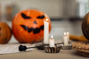 burning candles close up on a background of pumpkins. Halloween pumpkin head jack lantern with burning candles. illuminated halloween pumpkins with candles in the kitchen.