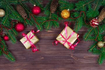 Christmas holiday background with gifts, fir tree and decorations on a wooden table. Place for an inscription. View from above. Copyspace.