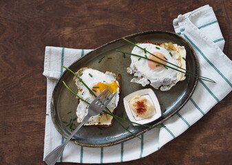 Open sandwiches with dark rye bread with cheese, fried egg and green onions on a wooden table.Healthy natural breakfast. View from above.