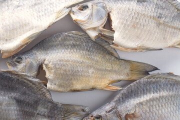 Dry river fish on white background. Salty beer appetizer. Dried carp with salt.