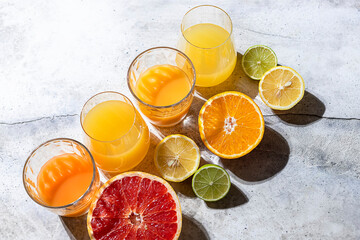 Citrus juice and fresh fruit, lime, grapefruit, orange, lemon in sunlight. Detox drink.