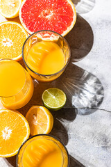 Citrus juice and fresh fruit, lime, grapefruit, orange, lemon in sunlight. Detox drink.