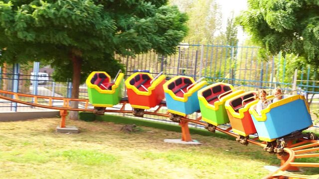 slow motion. roller coaster. car with girls rides on rails in amusement Park