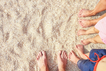 A Legs of the beautiful whole family on the sand near the sea background