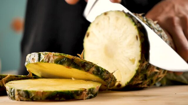 man cutting fresh pineapple slices- 4k