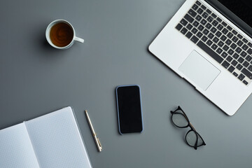Above view flat lay of laptop and business accessories on grey workplace background, copy space