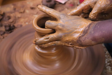 Fototapeta premium Hands And Fingers Posture Of Potter Making Pottery From Mud Using Spinning Potter Wheel