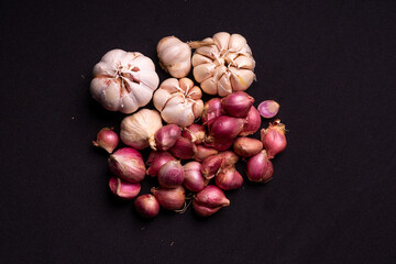 red onions and garlic on a black background