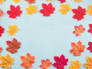 Obraz premium Colorful autumn maple leaves on turquoise background. Flat lay frame