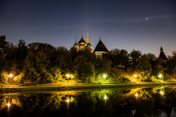Fototapeta premium ancient monastery by the lake at sunrise against the background of burning lanterns