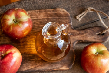 A bowl of apple cider vinegar with fresh apples