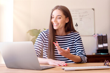 Happy businesswoman talking to her colleague about business plan in video conference