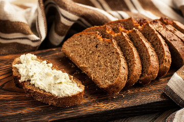 Slice of bread with butter on wooden board