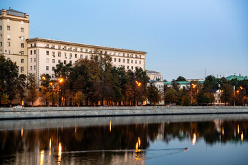 river embankment of a large metropolis at dawn with glowing lanterns reflections in the river