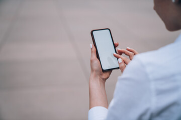 Crop woman looking at blank screen of phone
