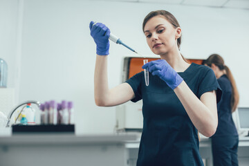 Professional lab technician conducting experiment and looking curious