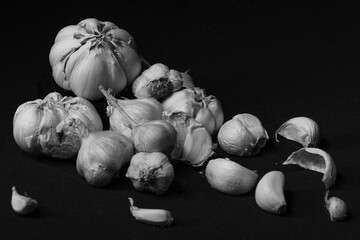 Garlic. garlic slices, garlic cloves, garlic tubers on a black background. Top view. black and white.