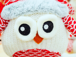 Cute knitted toy white owl with big eyes. Close-up photo
