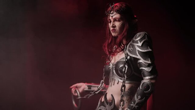 A costume on a girl for Halloween in the form of a warlike elf on a black background with smoke.