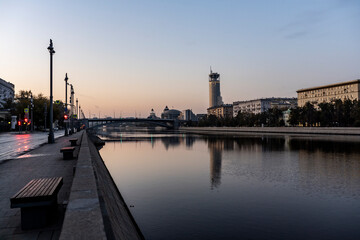 river embankment of a large metropolis at dawn with reflections in the river