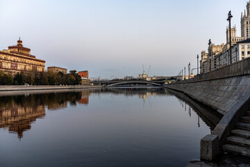 river embankment of a large metropolis at dawn with reflections in the river