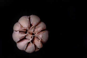 Garlic. garlic slices, garlic cloves, garlic tubers on a black background. Top view