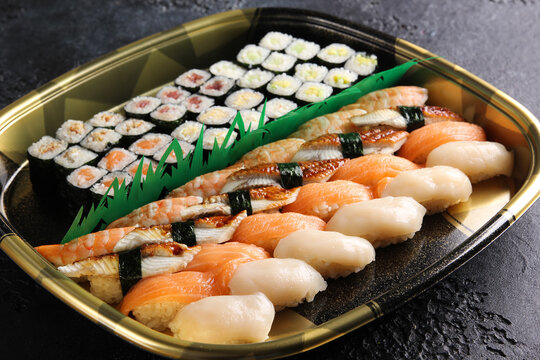 Japanese cuisine. Set of rolls and sushi on a black table. Food delivery. Background image, copy space